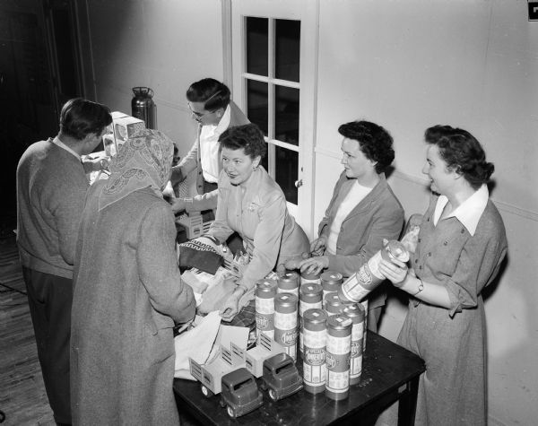 Four women help to distribute children's toys for the Empty Stocking Club at the Community Center. Left to right: Mrs. John Tews, Mrs. F.R. (Alice) Shores, Mrs. Rex (Maryon) Karney, and Helen Matheson.