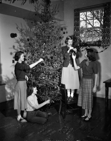 Members of the hospital junior auxiliary decorate a Christmas tree at Madison General Hospital prior to a holiday party for patients. They are, from left to right: Joan Sexton, auxiliary president; Louise Woodford, in charge of children's presents; Mary Sisk, party chairman; and Sally Vilas, in charge of decorating.