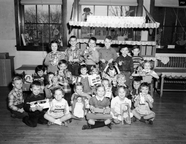 A group of children from a first grade class at Lowell School is shown with toys they washed, painted, and repaired to donate to the Empty Stocking Club.