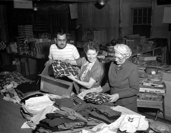Two women and a man working in the Empty Stocking Club's toy depot at the Madison Community Center.