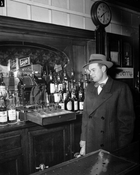 Homer T. Cochrane, owner of the Club Royal at 112 E. Washington Avenue, is shown eying one of the empty cash registers in his tavern shortly after armed bandits stole $515 while holding him and three employees at gunpoint.