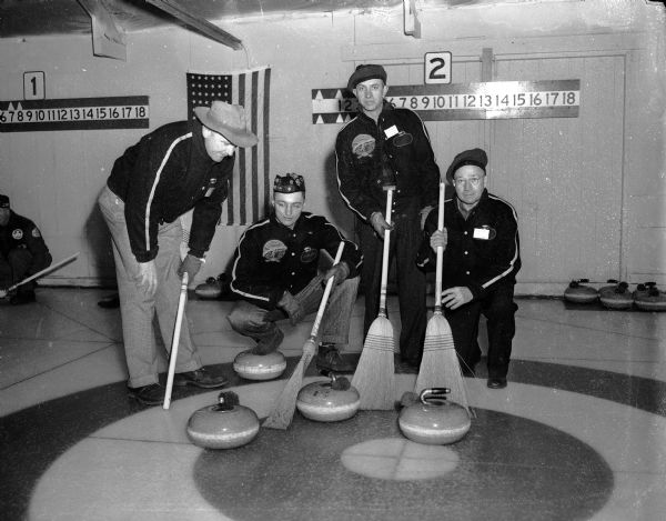 The Curtis Rink Curling Club of Portage poses on the ice at the Madison Curling Club. Shown from left to right are:  Bob Curtis, skip; Stu Taylor, 3rd; Varyl Achtenburg, 2nd; and Bob Cuff, lead.