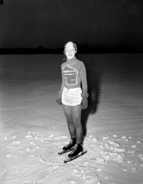 State champion speed skater Patricia "Pat" Gibson of Madison poses on the ice of Monona Bay while wearing a skating outfit.