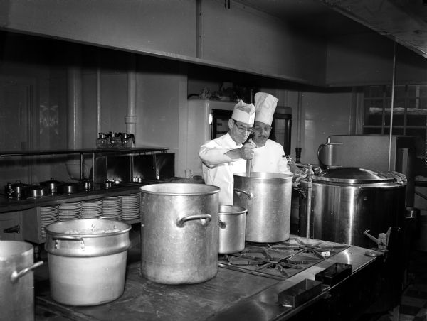 William Hovens of Trevor, Wisconsin, a student at the newly-opened Restaurant Institute at Madison Vocational School and a restaurent owner, mixing up a batch of beef stew stock as instructor Eldred Heisor is looking on.