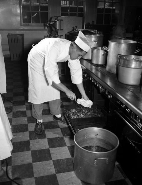Student Mauris Hostak of Kewaunee, Wisconsin checking on beef stew in the oven at the newly-opened Restaurant Institute at Madison Vocational School.