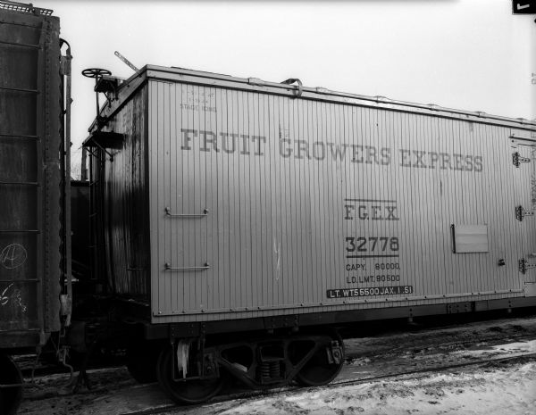 Exterior view of a wooden Illinois Central Railroad car labeled: "Fruit Growers Express."