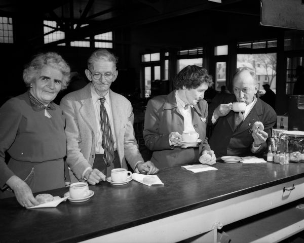 Older Adult Klub members enjoy snacks at the Madison Community Center. They are, from left: Mrs. Mabel Ott, Arthur Hawley, Mrs. Grace Ware, and Martin Nelson.