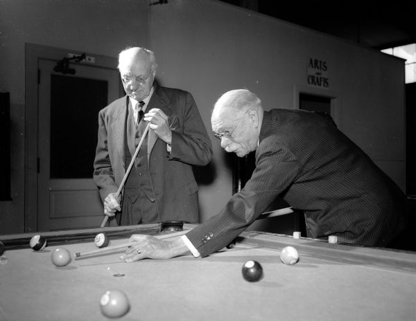 C.R. Cripps watching his friend J.W. Brown line up a shot during a game of pool at the Madison Community Center during a gathering of the Older Adult Klub.