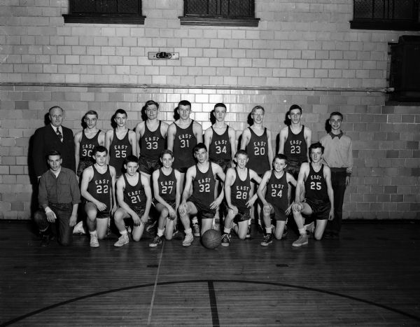Group portrait of East High junior boys' basketball team, in uniform, with Coach Floyd Ferrill and manager Carl Hubbard.