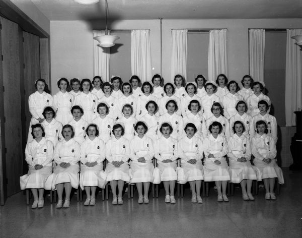 Forty nursing students at St. Mary's Hospital School of Nursing receive their caps at a ceremony in the hospital chapel. The nurses have successfully completed their preparatory period, the first goal in their nursing education and training.