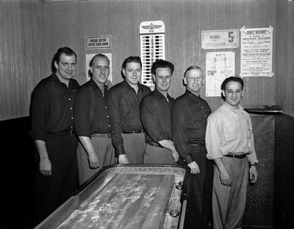 Group portrait of the Kaether's Bar shuffleboard team, which is scheduled to play in the finals of the city championship tournament. Pictured from left to right are: Glenn Petraske, George Jaegers, Jack Norton, Les Marx, Leo Donovan, and John Lonielle. Kaether's Bar was located at 119 East Main Street.