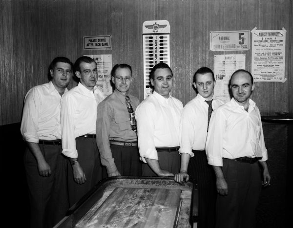 Group portrait of the Silver Dollar Tavern shuffleboard team, which is playing in the finals of the city championship tournament.  Pictured from left to right are: Jack Meixl, Bud Martin, Orv Sims, Joe Teasdale, Ray Skinner, and Bill Wilson. The Silver Dollar Tavern was located at 117 West Mifflin Street.