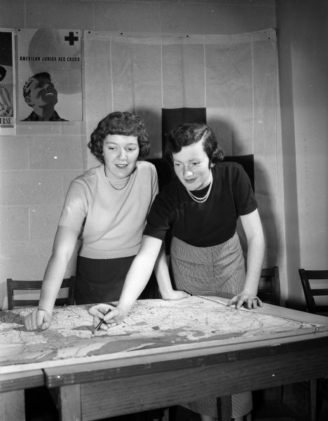 Members of the Junior Red Cross, Ruby Kepler of Central High School and Dorothy Lacey of Edgewood High School, looking at a map. They are being trained as aircraft spotters.
