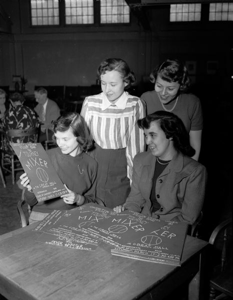 Some of the members of the Youth Council service committee work on arrangements for entertainment during the state high school basketball tournament. Seated are Sylvia Sachtjen and Barbara Loos. Standing behind them are Lois Brustman and Donna Daentl.