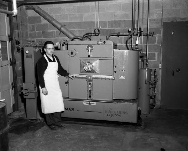 An employee stands beside the new cleaning machine at Mullarky's Spic and Span Inc. dry cleaners, 3322 University Avenue.