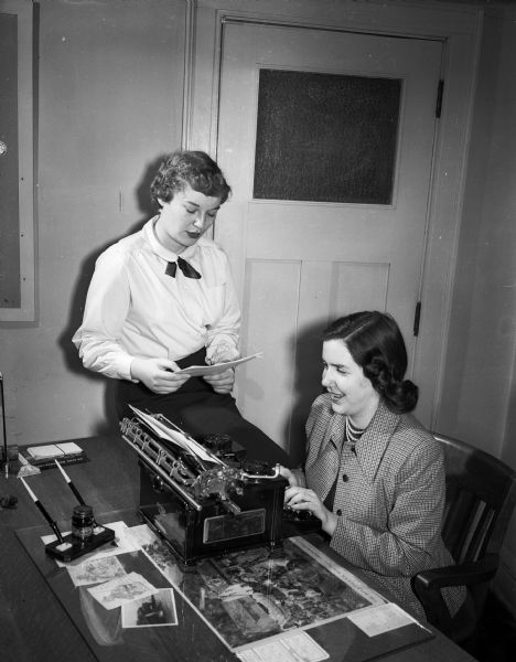 Two Madison senior girl scouts work on housing arrangements for the upcoming Senior Girl Scout Conference of Southern Wisconsin and Northern Illinois. Seated at the typewriter is Margaret Brigham, and looking on with the housing list is Nancy Donkle.