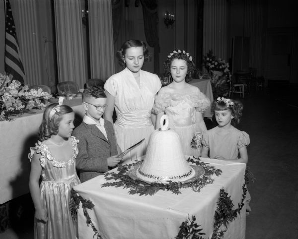 Members of the Timothy Hatch Society of the Children of the American Revolution take part in the commemoration ceremony in recognition of the founding of Madison's John Bell chapter of Daughters of the American Revolution (DAR) held during the DAR's fifty-fifth annual state convention. Pictured left to right: Ruth Cottrell, Gary Lee Seymour (cutting the cake), Barbara Cottrell, and Gail and Jacqueline Harman.