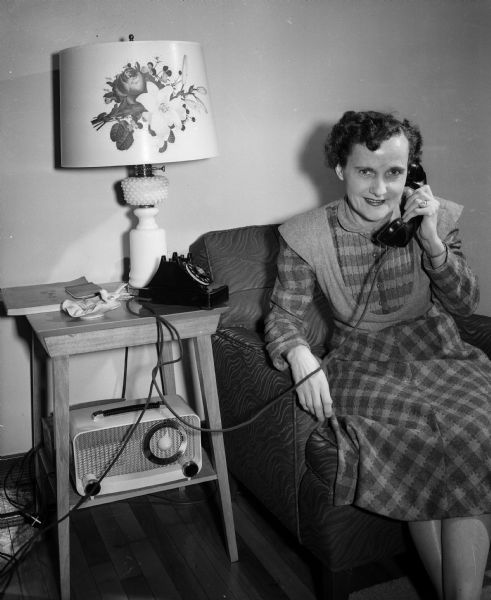 Mrs. Wesley Morrison of 403 Rogers Street talks on the phone with the Dane County Red Cross while asking for assistance in obtaining a leave for her son, Corporal John Morrison, because of her husband's poor health.