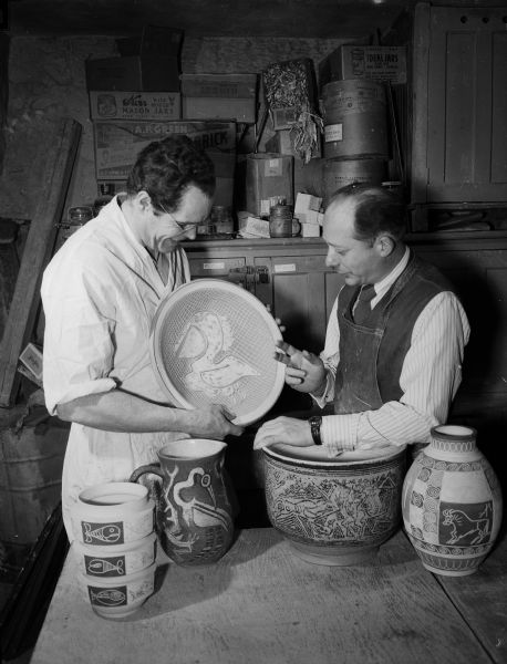 F. Carlton Ball (left), University of Wisconsin Assistant Professor of Art, and Aaron Bohrod, University of Wisconsin Artist in Residence, pose for a portrait with decorated pottery on which they collaborated.