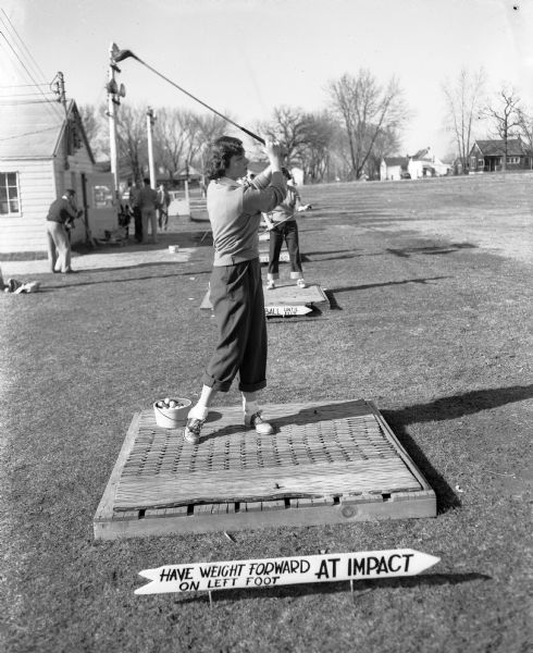 Joan Wilke, a university student from Milwaukee, practicing her golf swing at the Fairway Golf Range, 2211 South Park Street.