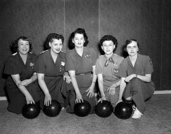 Group portrait of the Bee's Tavern women's bowling team, the champion team of the 1951 Madison Woman's Bowling Association. Pictured from left to right are: Bobby Belling, Ora Ehl, Priscilla Siewert, Marcy Kleinsteiber, and Frances Fischl. Bee's Tavern was located at 1109 South Park Street. Some of the women are wearing "600 Club WIBC" patches.