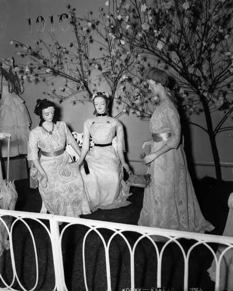 Three mannequins stand on a display at a garden party as part of the collection on exhibit at the State Historical Society of Wisconsin. Items are from the collection of the late Mr. and Mrs. George Douglass Van Dyke of Milwaukee.
