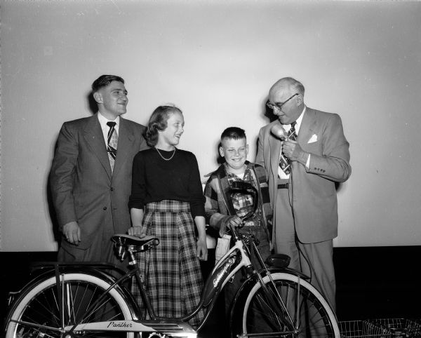 Top prize winners in the JCC safety slogan contest posing with a new bicycle and contest officials. Left to right: Harry Tobias, chairman of the contest; Susie McBeath and Mike Webber, prize winners; and R.C. "Bert" Salisbury of the state motor vehicle department.