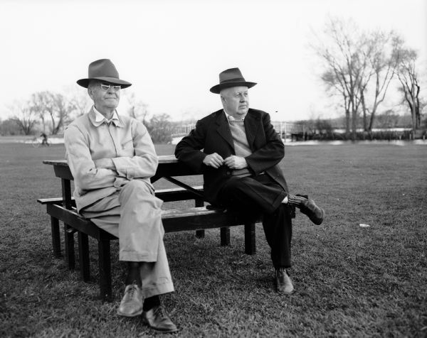George "Dad" Thompson, (left) and Matt Brossard sitting on a bench at Vilas Park Diamond #2 while watching the St James CYO vs. Hardy's softball game, which was one of the games opening Madison's 1951 softball season.