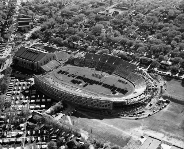 Aerial view of Camp Randall Stadium and Fieldhouse looking west. The photograph was taken during a ROTC annual inspection.
