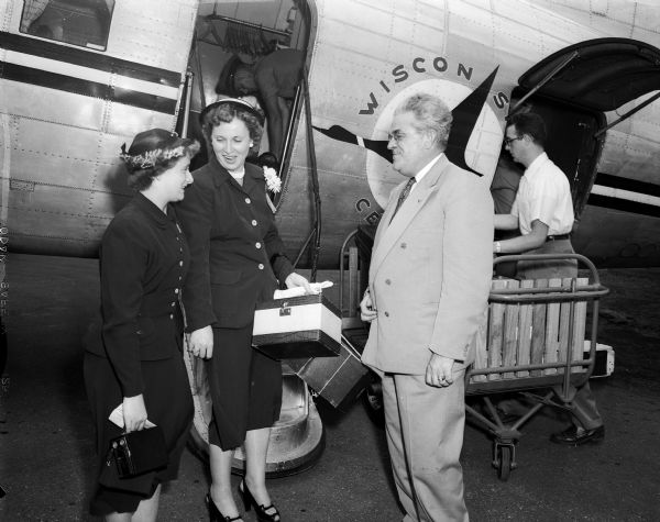 Bonnie Wainscott (left), age 16, and her mother Mrs. Grace Wainscott are greeted by Francis M. Higgins, President of Wisconsin Central Airlines. The Wainscotts appeared on Tommy Bartlett's "Welcome Traveler" program in Chicago and a visit to Madison was arranged through the Wisconsin Central Airlines and the Edgewater Hotel. Bonnie was stricken with polio when she was 13 months old, and Mrs. Higgins was a polio victim in 1907.