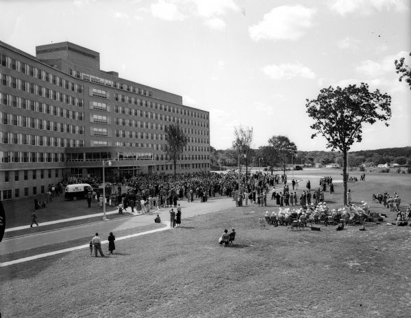Elevated view of a crowd gathered on the lawn in front of the new Veterans Administration Hospital during the dedication ceremony.
