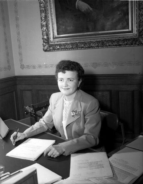 Doris Porter, of 1224 Jennifer Street, sits behind a desk in an office. She is the private secretary to Governor Walter J. Kohler.
