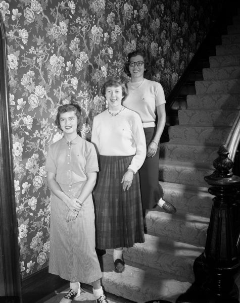 Three new Madison pledges of the Delta Delta Delta sorority at the University of Wisconsin pose on a staircase for a portrait. From left to right are: Renee L'Hommedieu, Libby Grimmer, and Patricia Jefferson.