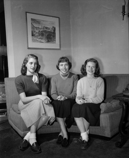 Three new Madison pledges of the Alpha Xi Delta sorority at the University of Wisconsin sit on a couch for a portrait. From left to right are: Ruth Pickett, Betty Searle, and Virginia Halvorson.
