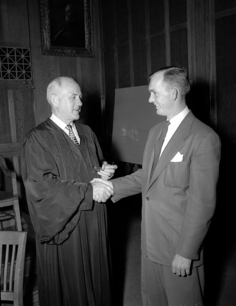 Federal Judge Patrick T. Stone shaking the hand of his son-in-law, William F. Yeschek, who was admitted to practice law in the western Wisconsin federal district court.