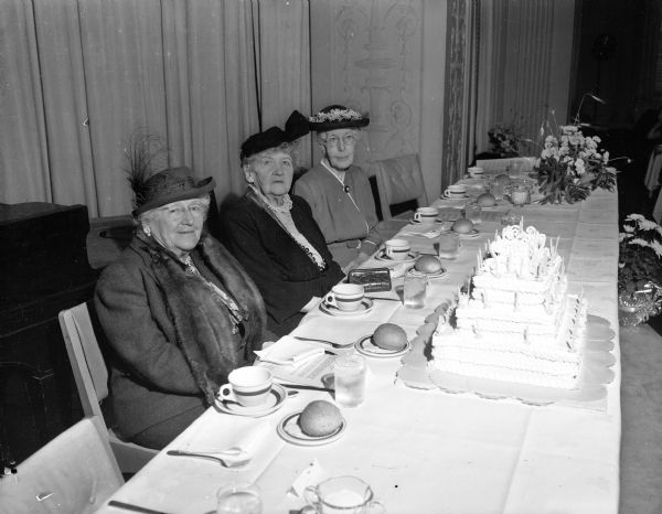 Three charter members of the University League were paid special tribute at the fall luncheon which marked the 50th anniversary of the organization. Shown with the elaborate birthday cake are, from left to right, Mrs. M.S. Slaughter, Mrs. Frederic K.(Grace) Conover, and Mrs. A. A. (Jennie) Knowlton.