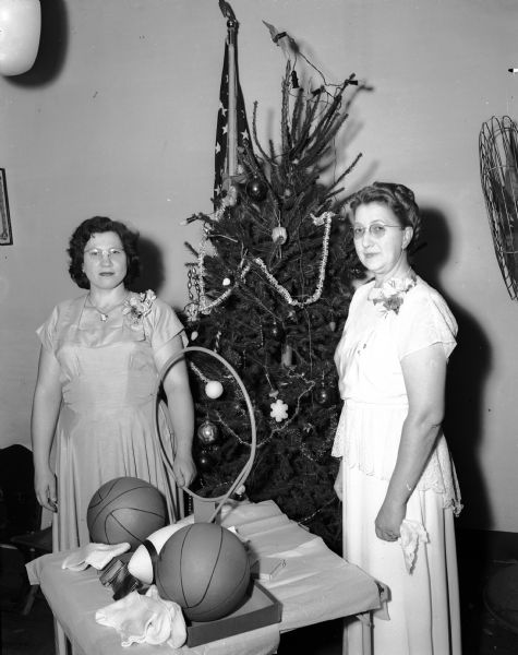 Pictured at the annual Women of the Mooses' "Christmas party" with some of the gifts to be given to children of Mooseheart, Illinois are, at left, Mrs. Herman Haack, chairman of the Mooseheart committee, and at right, Mrs. Harry S. (Elsie) Bostock, senior regent of the Madison chapter. The gifts are sent in the fall to Mooseheart officials who will wrap and distribute them at Christmas to individual children.