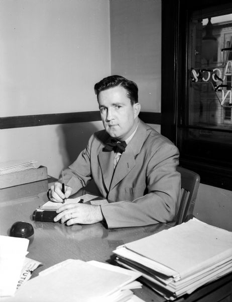 Portrait of a man, probably Joseph O'Brien of the Badger Insurance Agency, seated at a desk.