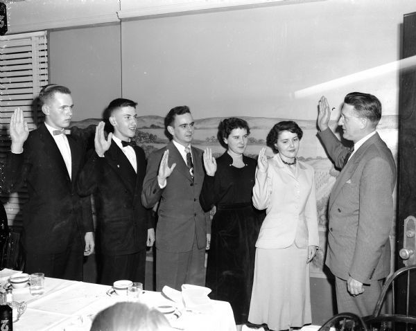 New officers of the Madison Youth Council are given their oath by City Clerk A.W. Bareis, at far right. Left to right are: Harold Haak, treasurer; John Hobbins, president; Don Nolter, vice-president; Sue Ann Burns, recording secretary; Mary Alice McCormick, corresponding secretary, and Mr. Bareis.