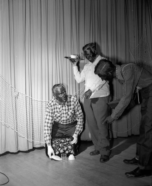 The "Old South" came to life as the Shorewood Hills Community League presented its minstrel show to Shorewood Hills residents and guests. "End men" in blackface, Fritz Carpenter, kneeling at left, and Dr. J.T. Schwab, standing in center, trade jokes with master of ceremonies Dr. Robert C. Parkin, right.