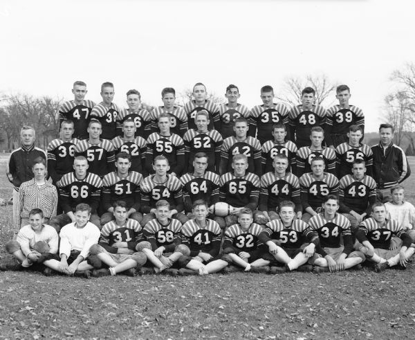 Outdoor group portrait of the Prairie du Sac High School football team and coaching staff, winners of the Tri-County League championship.