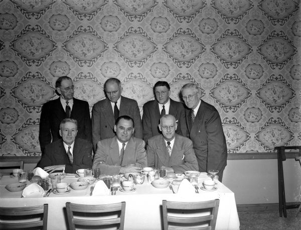 Head table at a dinner honoring two retiring city employees, Tim Harrington, City Engineer and Art Lundholm, electrical engineer. Seated, left to right: Tim Harrington, Mayor George Forster, and Art Lundholm. Standing, left to right: Former Mayor, I. Milo Kittleson, former Mayor, F. Halsey Kraege, and City Clerk, A. W. Bareis.
