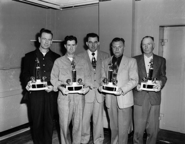 Five Home Talent Baseball League team managers hold four trophies emblematic of their teams winning sectional titles during the 1951 campaign. Left to right are: Con Thompson, McFarland; George Beiderman, Cross Plains; C.A. Lewis, league commissioner; Ray Lamboley, Waunakee, and Harvey Hurd, Rio. Lamboley's Waunakee team also won the league championship.