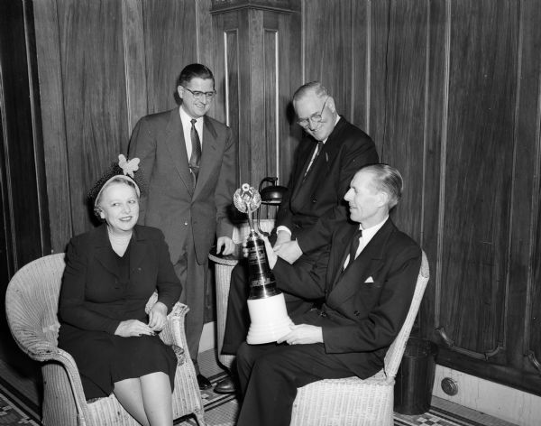 Group portrait of the winners of the United Givers Fund campaign. Shown are, left to right: Mrs. Oscar (Inez) Toebaas, chair of the women's division; Stanley Kubly, associate campaign chair; Dean John Guy Fowlkes, general campaign chair; and Leslie Pollard, chair of the advanced gifts division, holding a trophy.