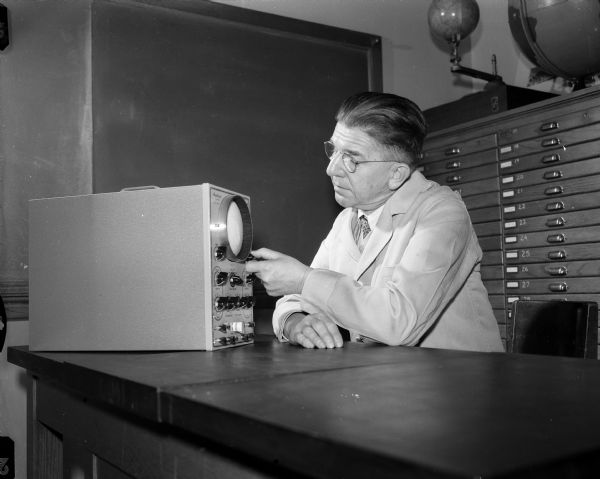 Madison West High School physics teacher Frederick Schuler works with an oscilloscope.