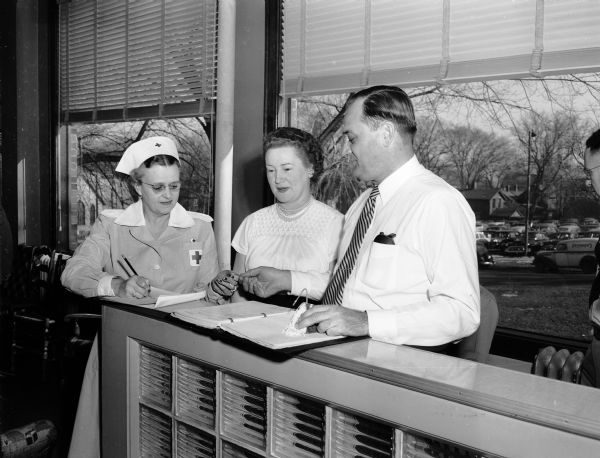 Mayor and Mrs. George and Frances Forster prepare to donate blood as volunteer Grey Lady Mrs. Margory Colvin (left) looks on.