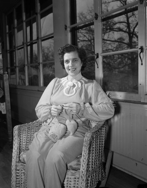 Marguerite Willenberg of 1027 East Johnson Street, a tuberculosis patient at Morningside Sanatorium, is sitting in a wicker rocking chair while knitting.