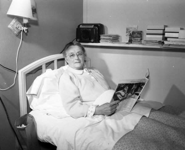 Isa Shower, a tuberculosis patient at Lake View Sanatorium, reads while lying in bed.