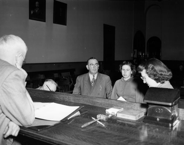 Alice Yngsdahl, center right, is shown in Superior Court with her attorney, W. Curtis Farmer, as Court Clerk Virginia McRedmond, right, reads the complaint charging her with larceny of credit union funds. On the bench is Judge Roy H. Proctor.