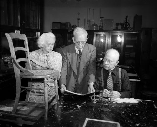 Constructive Workshops for Older Adults, created by the Vocational School, offers many leisure time activities for newly-retired men and women. Pictured left to right are: Mrs. Augusta Binger, working at chair caning; Leo Husting, center, involved in a book binding project, and Adolph Hansen, right, making a copper bracelet.